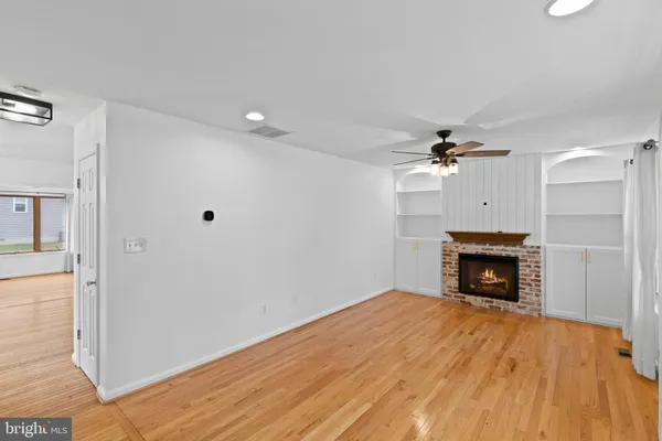 a view of empty room with wooden floor and fireplace