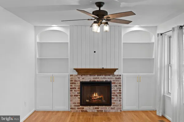 a living room with a fireplace and a ceiling fan
