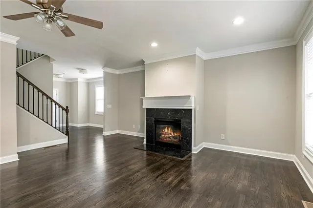 a view of an empty room with wooden floor fireplace and a window