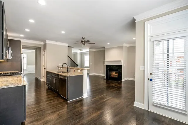 a large kitchen with a center island wooden floor and a fireplace