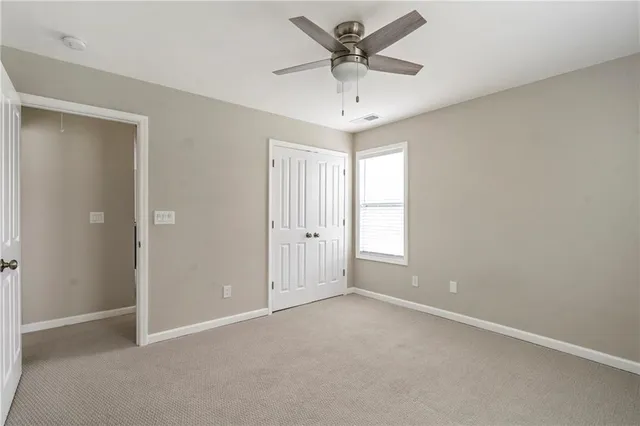 an empty room with a ceiling fan and a window