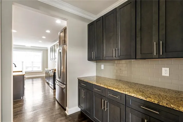 a view of a kitchen with stainless steel appliances granite countertop wooden cabinets and a counter top space