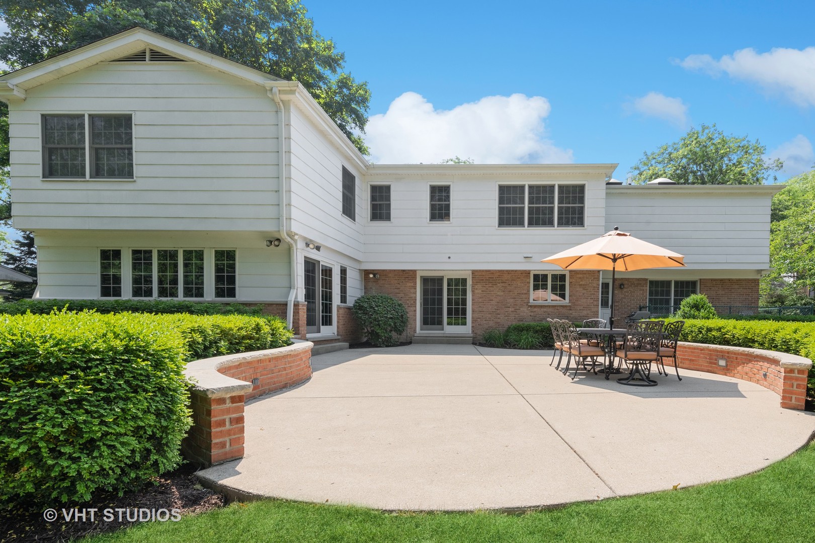 275 Old Mill Road Barrington, IL 60010 - Photo 36 of 45 a view of a white house with a patio table and chairs under an umbrella
