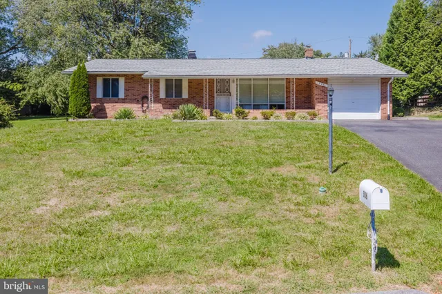 a front view of house with yard and green space