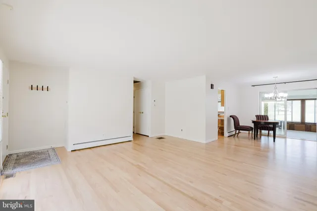 an empty room with dining table and chairs
