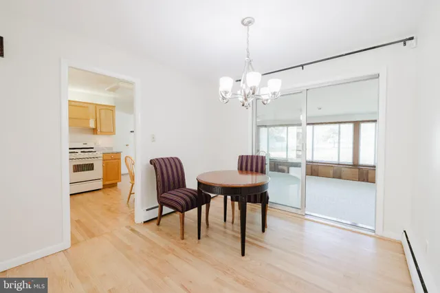 a dining room with furniture a chandelier and wooden floor
