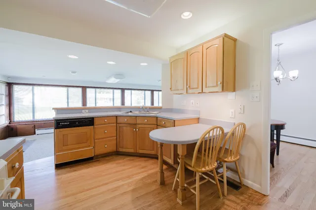 a kitchen with a table chairs sink and wooden floor