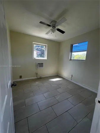 an empty room with a ceiling fan and carpet