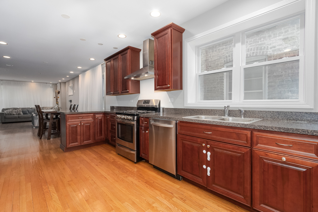 1234 Maple Avenue Berwyn, IL 60402 - Photo 7 of 25 a kitchen with stainless steel appliances granite countertop a stove a sink and a microwave
