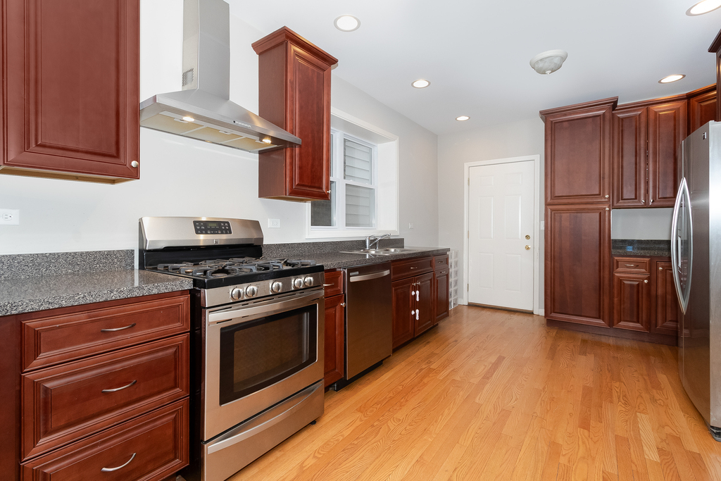 1234 Maple Avenue Berwyn, IL 60402 - Photo 8 of 25 a kitchen with stainless steel appliances granite countertop a stove a sink and a refrigerator