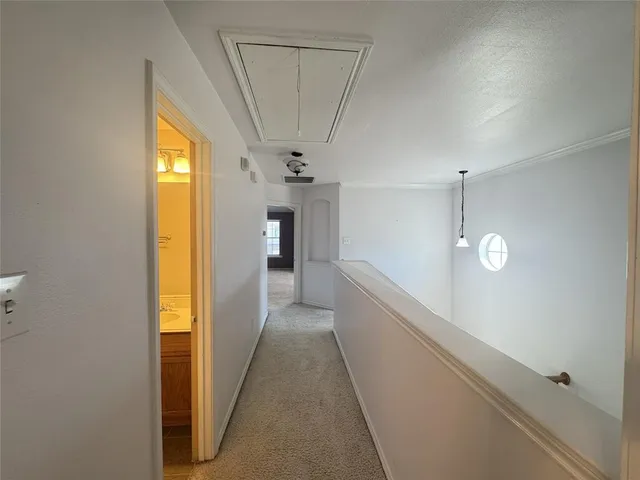 an empty room with a chandelier fan and windows