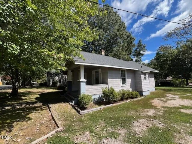 a view of a yard in front of a house with large tree