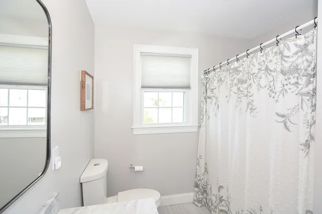 a bathroom with a toilet and a shower curtain