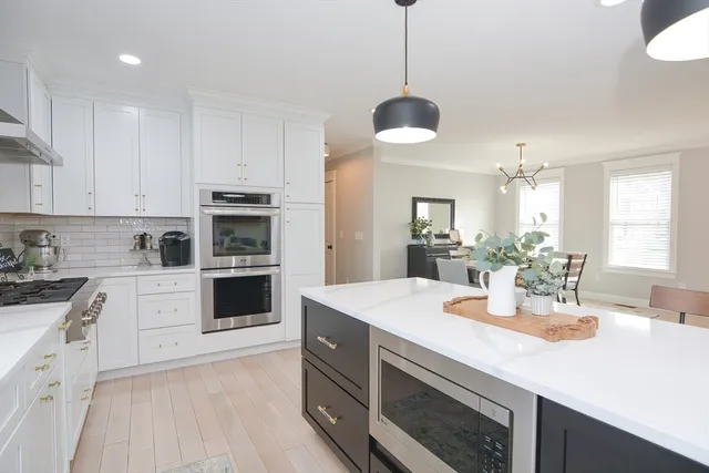 a kitchen with a center island appliances and cabinets