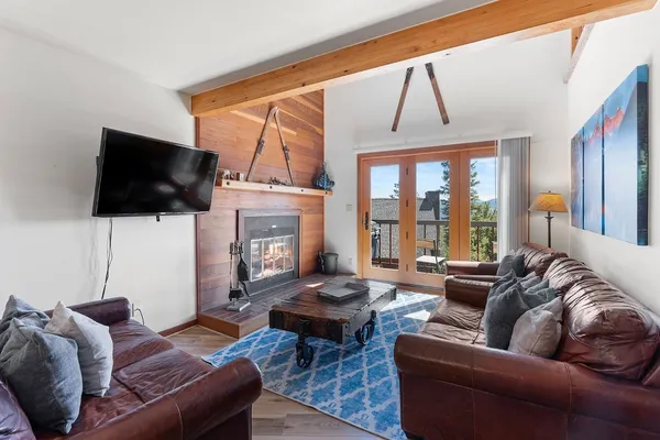a living room with furniture a flat screen tv and a large window