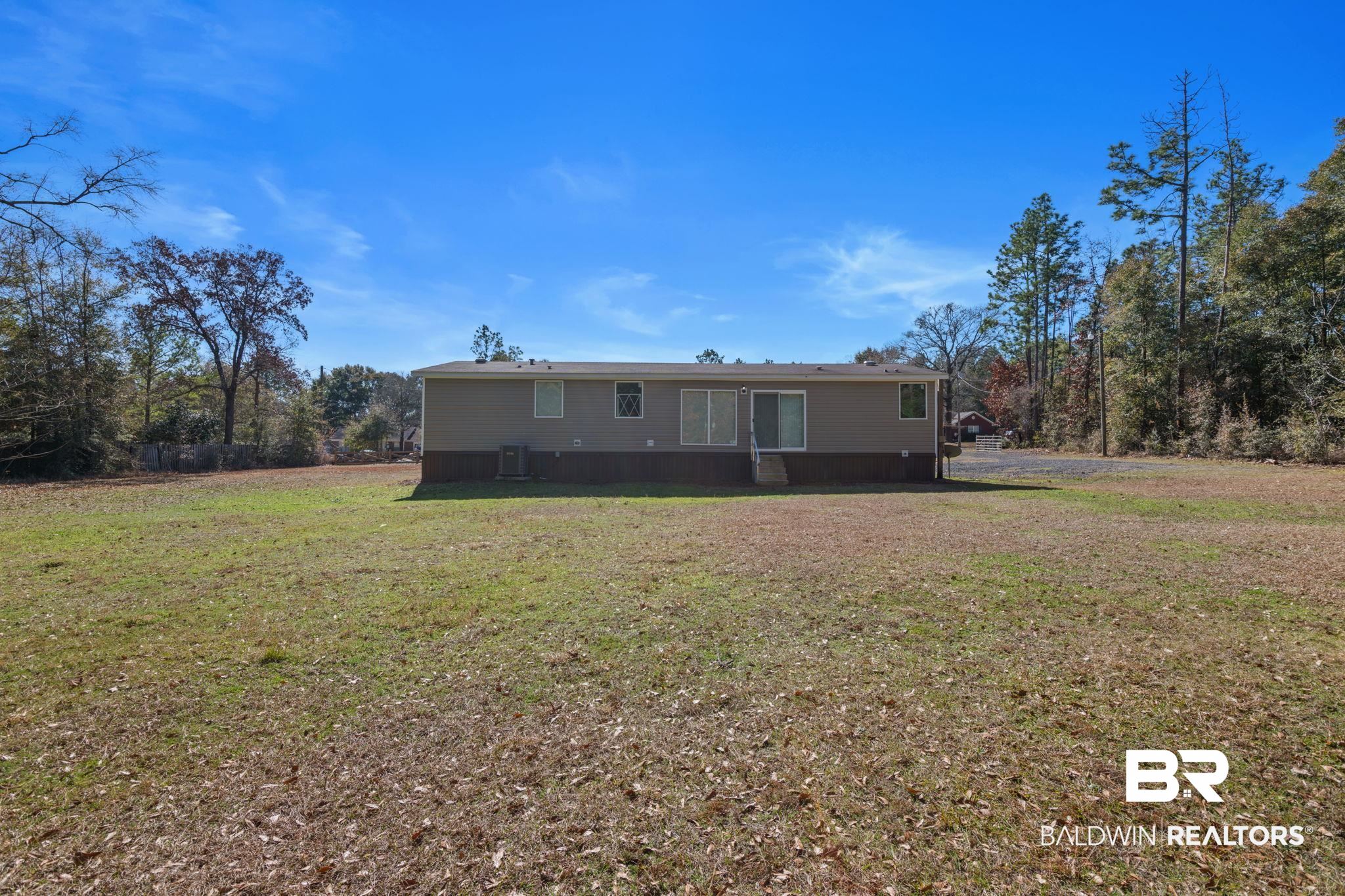 15080 Starlight Avenue Wilmer, AL 36587 - Photo 28 of 29 View of front of house featuring central AC and a front yard