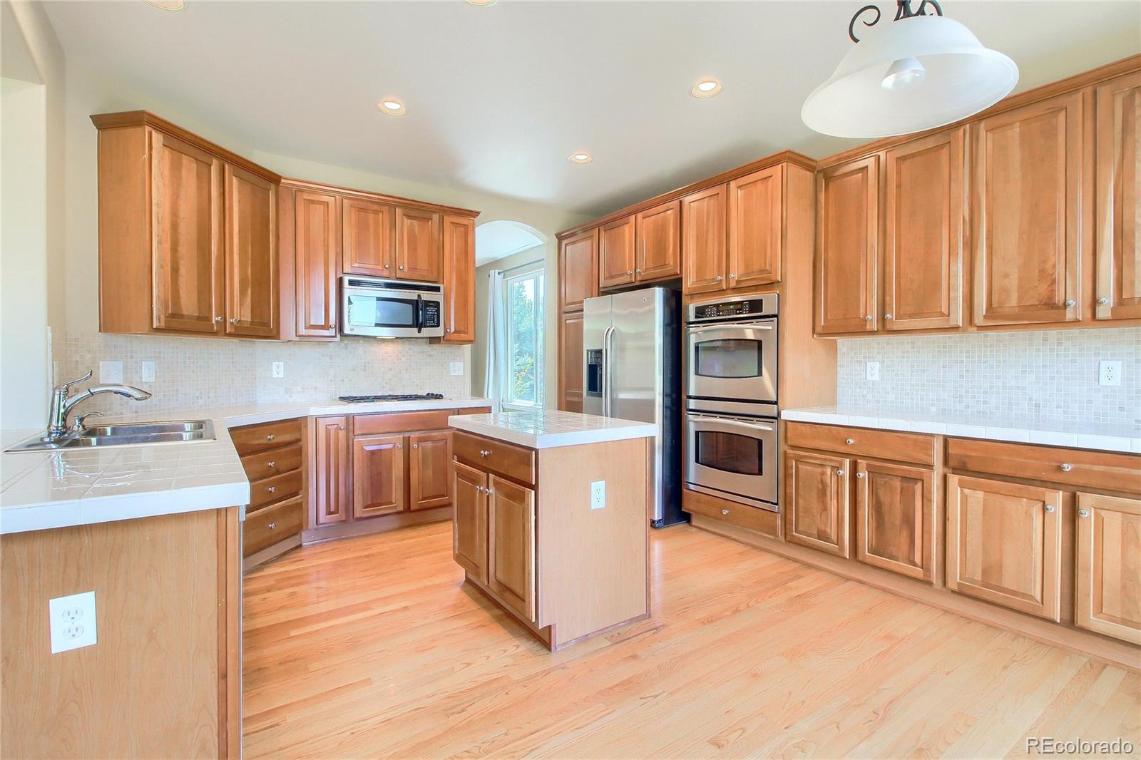 2705 Middlebury Drive Highlands Ranch, CO 80126 - Photo 3 of 40 a kitchen with stainless steel appliances granite countertop a refrigerator sink and cabinets