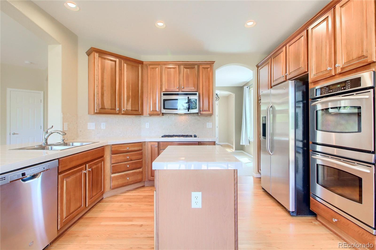 2705 Middlebury Drive Highlands Ranch, CO 80126 - Photo 5 of 40 a kitchen with stainless steel appliances granite countertop a refrigerator sink and microwave