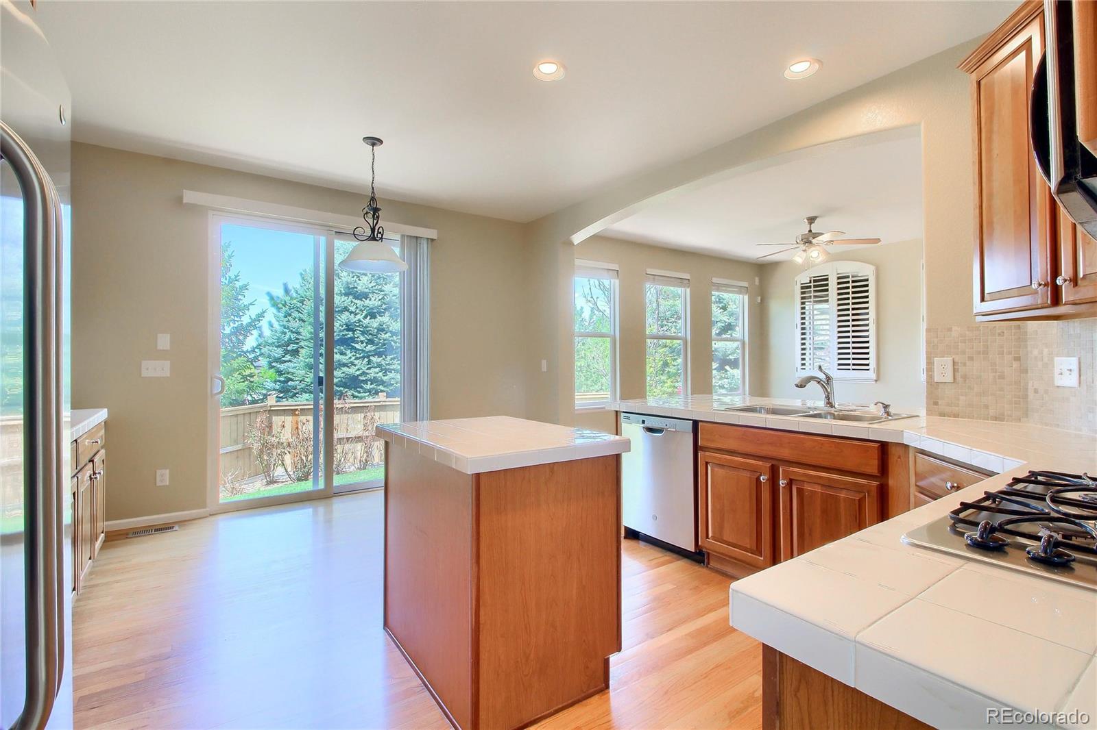 2705 Middlebury Drive Highlands Ranch, CO 80126 - Photo 6 of 40 a kitchen with a stove a sink a refrigerator and wooden floor