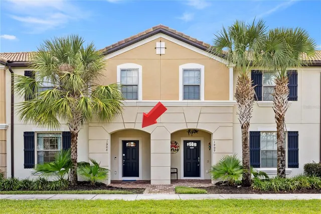a front view of a house with yard and palm tree