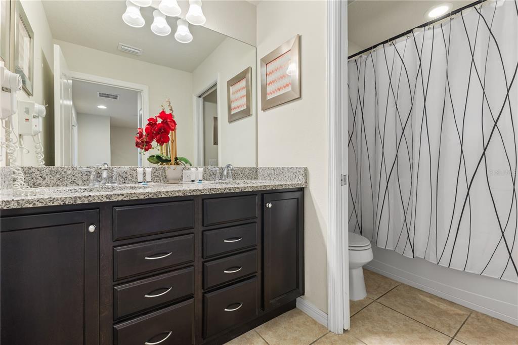 1905 Majorca Drive Kissimmee, FL 34747 - Photo 12 of 59 a bathroom with a granite countertop sink and a mirror