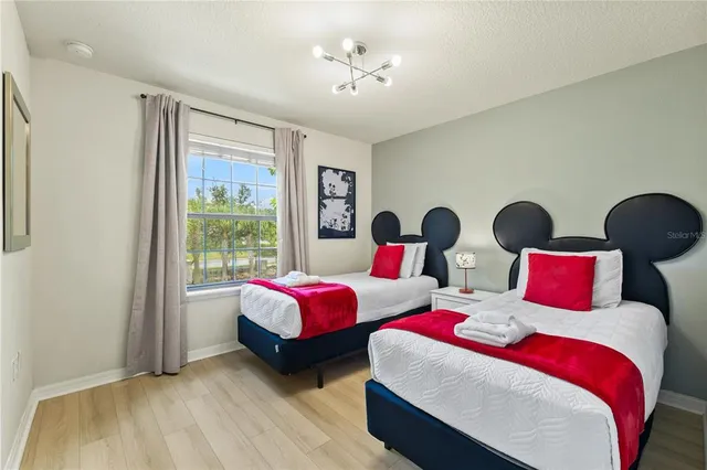 a bedroom with two beds and painting on the wall