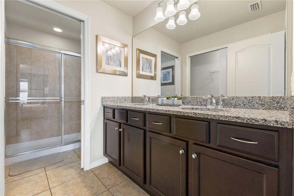 1905 Majorca Drive Kissimmee, FL 34747 - Photo 23 of 59 a bathroom with a granite countertop sink a mirror and a shower