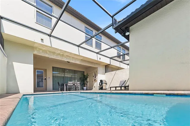 a view of a white house with a yard and palm trees
