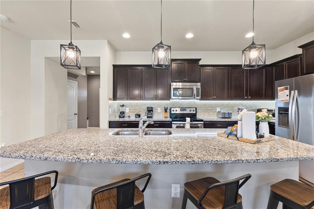 1905 Majorca Drive Kissimmee, FL 34747 - Photo 41 of 59 a kitchen with stainless steel appliances granite countertop a sink refrigerator and microwave