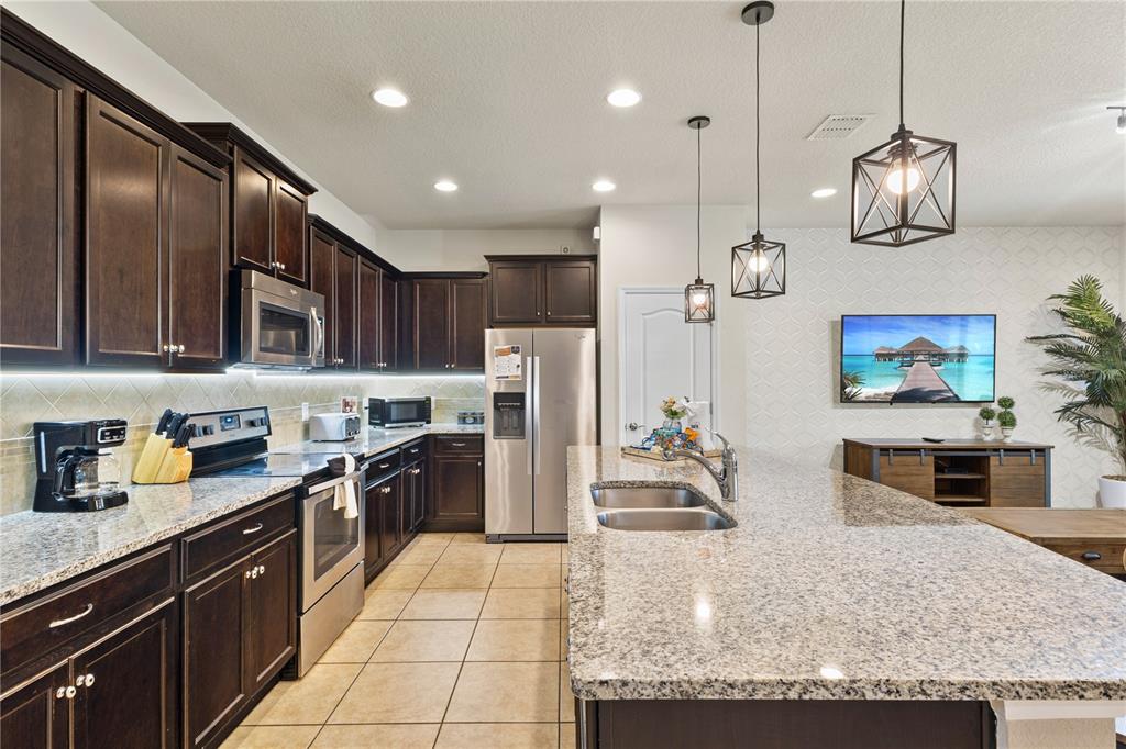 1905 Majorca Drive Kissimmee, FL 34747 - Photo 44 of 59 a kitchen with stainless steel appliances granite countertop a sink refrigerator and cabinets
