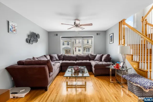 a living room with furniture a ceiling fan and a window