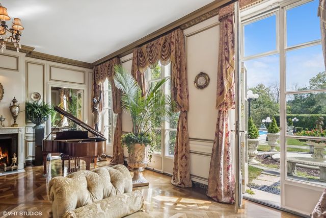 a kitchen with stainless steel appliances granite countertop a stove a refrigerator a kitchen island a couches and a fireplace with wooden floor