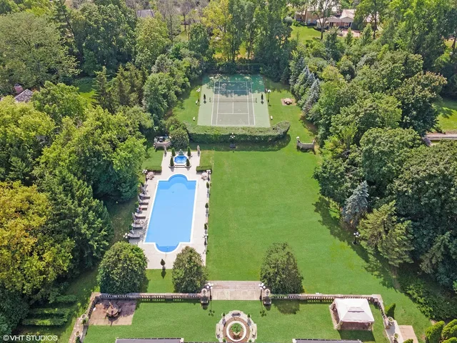 an aerial view of a house with a garden and swimming pool