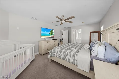 a spacious bedroom with a bed and a tv