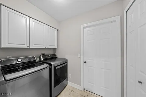 a kitchen with white cabinets and black appliances