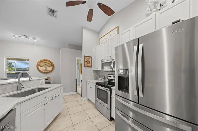 a kitchen with stainless steel appliances granite countertop a refrigerator and a sink