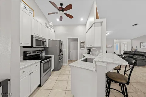 a living room with stainless steel appliances kitchen island granite countertop furniture and a kitchen view