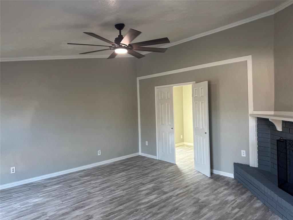 2125 Kings Road Carrollton, TX 75007 - Photo 4 of 33 a view of an empty room with wooden floor fireplace and a window