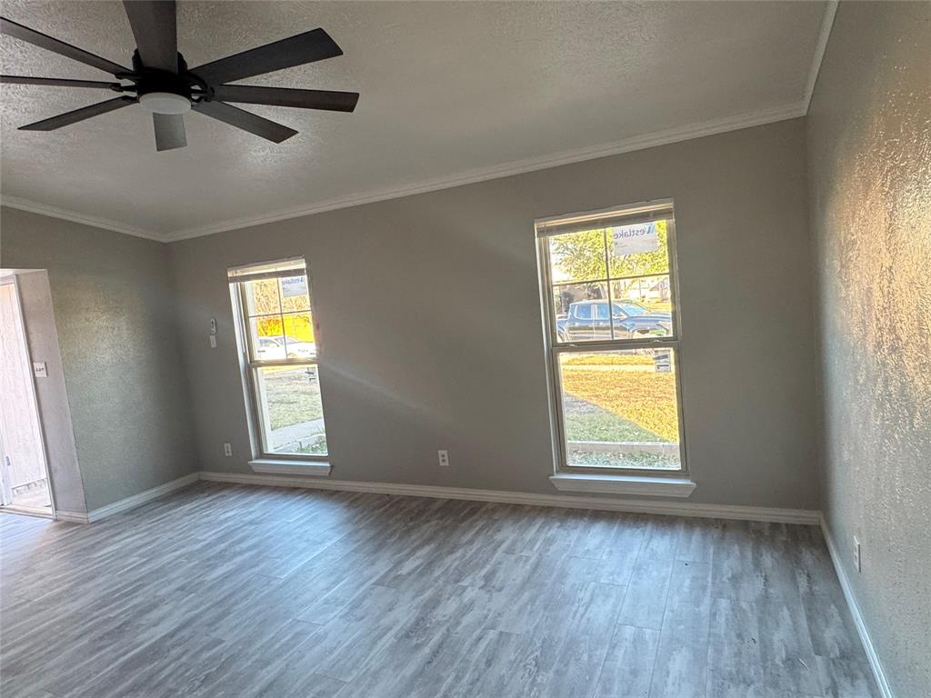 2125 Kings Road Carrollton, TX 75007 - Photo 10 of 33 an empty room with wooden floor fan and windows