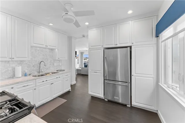 a kitchen with stainless steel appliances a refrigerator sink and cabinets