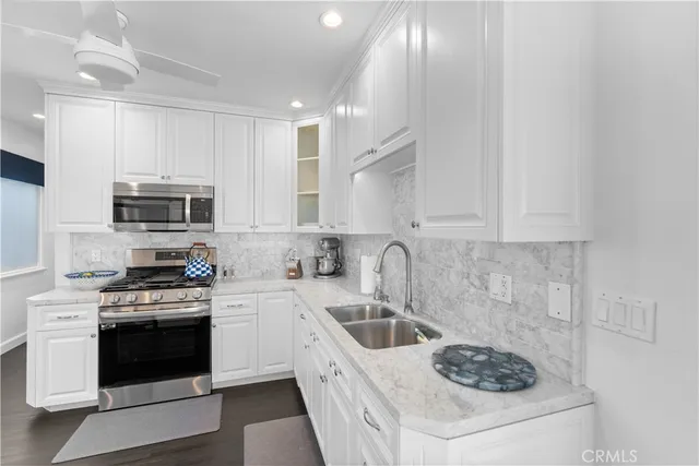 a kitchen with white cabinets and stainless steel appliances