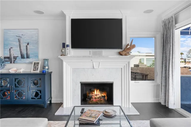 a living room with a fireplace a flat screen tv and a window