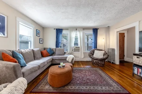 a living room with furniture a rug and a large window