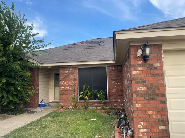 front view of a brick house with a yard