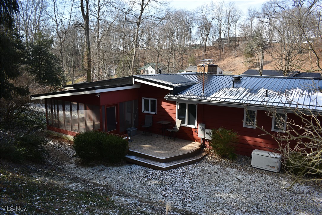 Rear view of house featuring a sunroom