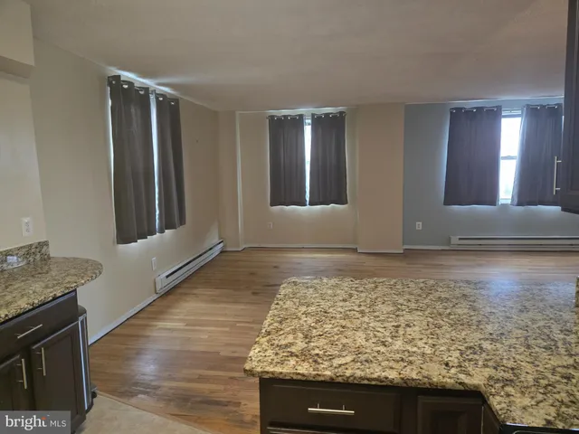 a view of a room with wooden floor and brick walls