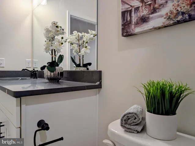 a bathroom with a sink a toilet and a mirror