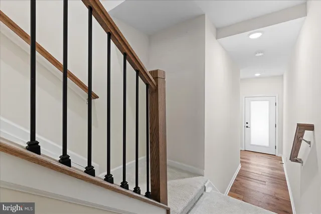 a view of staircase with lots of frames on wall and a window