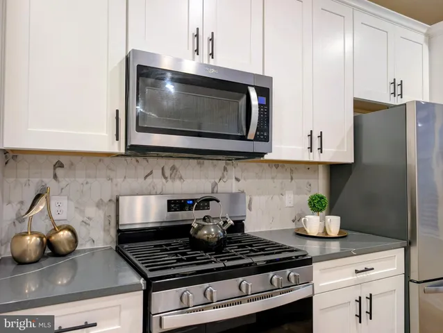 a kitchen with stainless steel appliances granite countertop a stove a microwave and cabinets