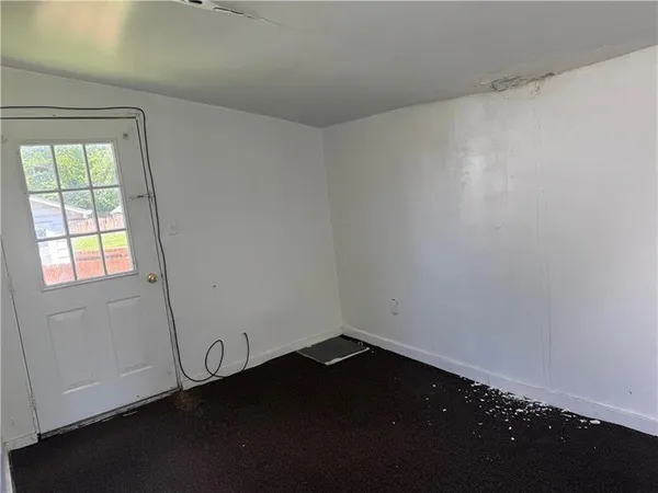 en empty room with wooden floor and windows